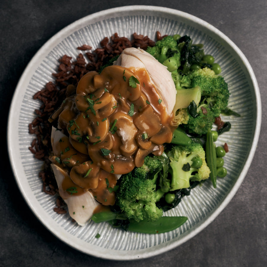 真空低溫烹調雞胸肉配蘑菇肉汁、混合綠色蔬菜和蒸泰式紅米飯