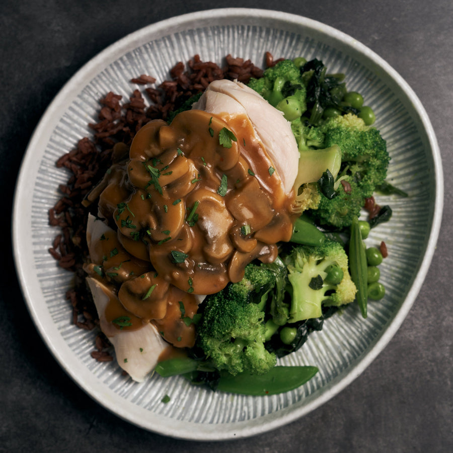 真空低溫烹調雞胸肉配蘑菇肉汁和混合綠色蔬菜