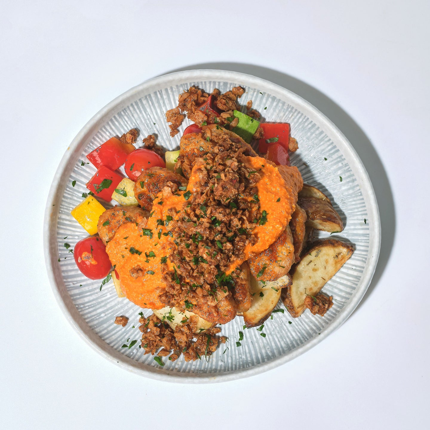 Plant-Based Fish in Romesco Sauce with Plant-Based Pork Mince, Zucchini, Peppers, Tomato & Roasted Rosemary Potato